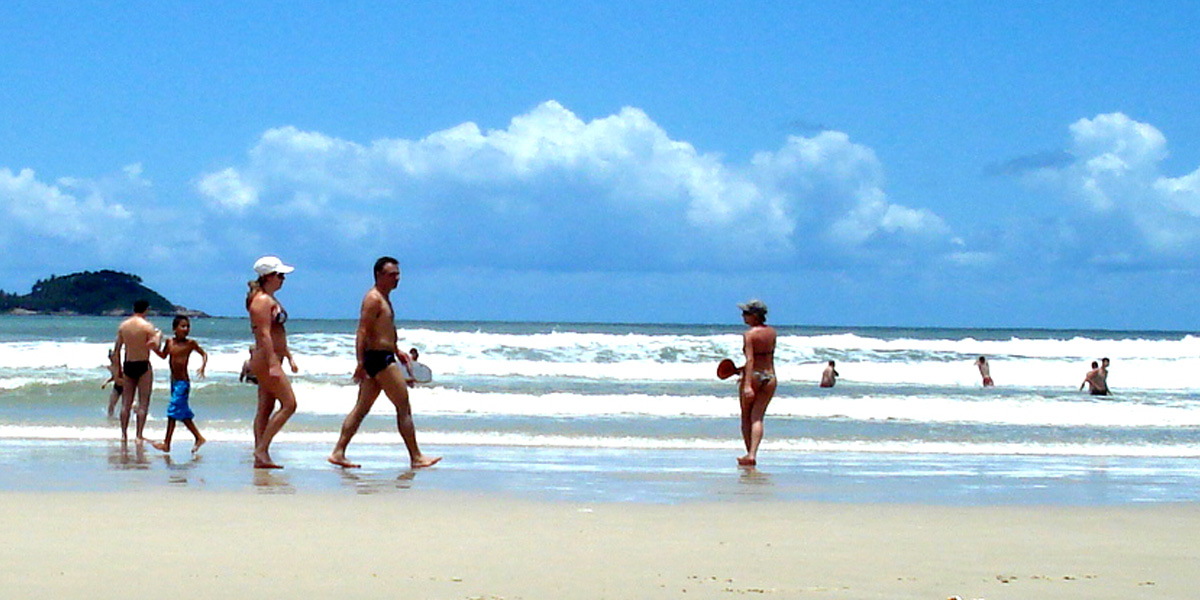 banhistas passeando na praia da enseada